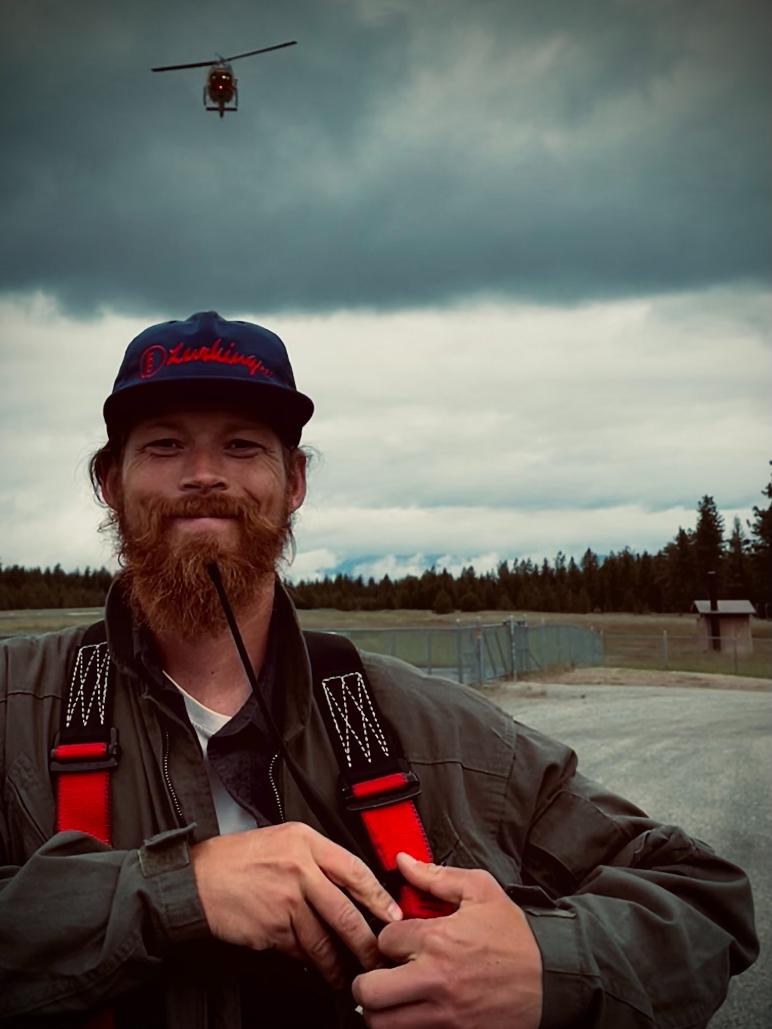 Ken Browning in rappel gear with helicopter overhead