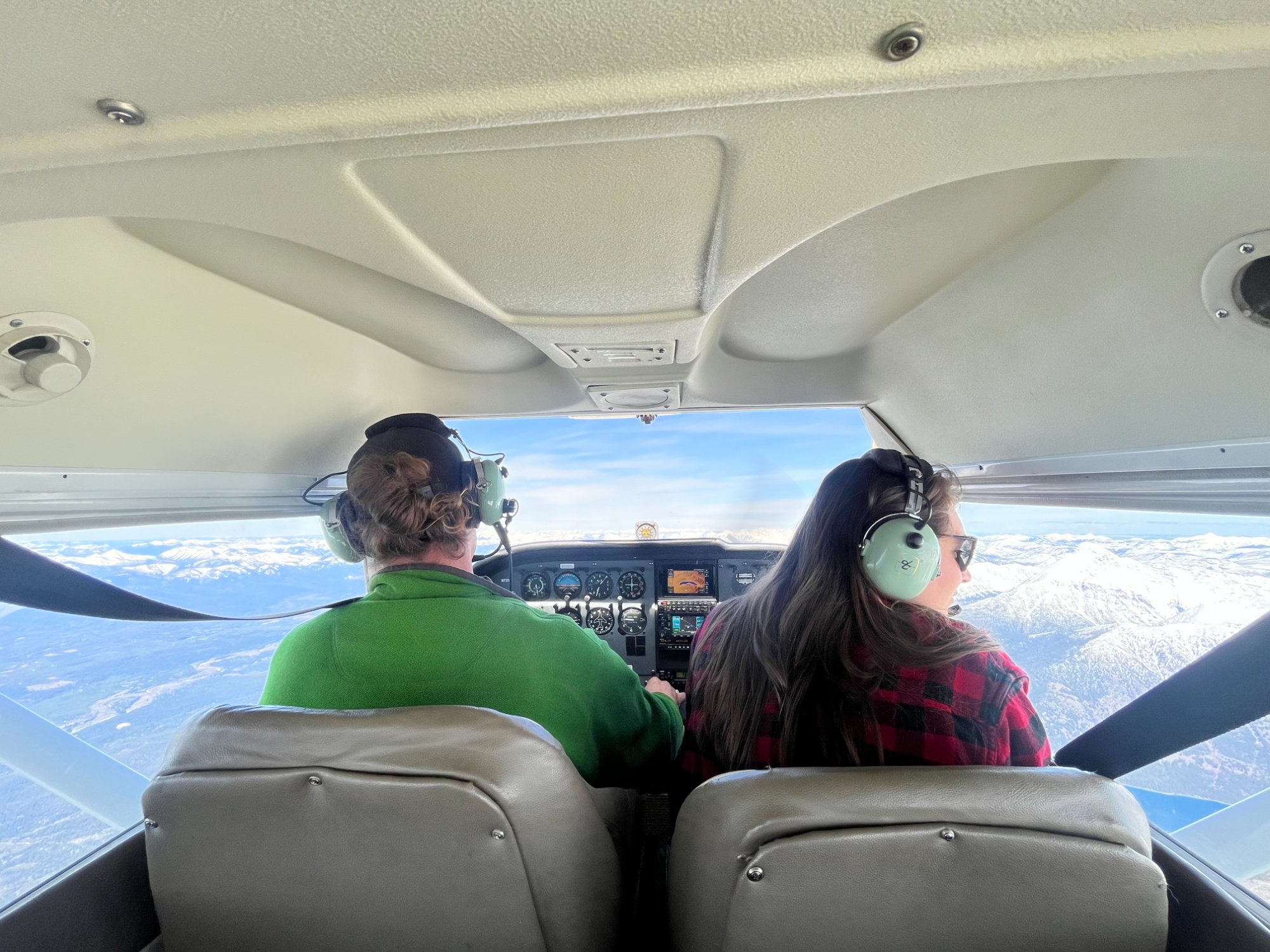 View from aircraft cockpit over snowy mountains