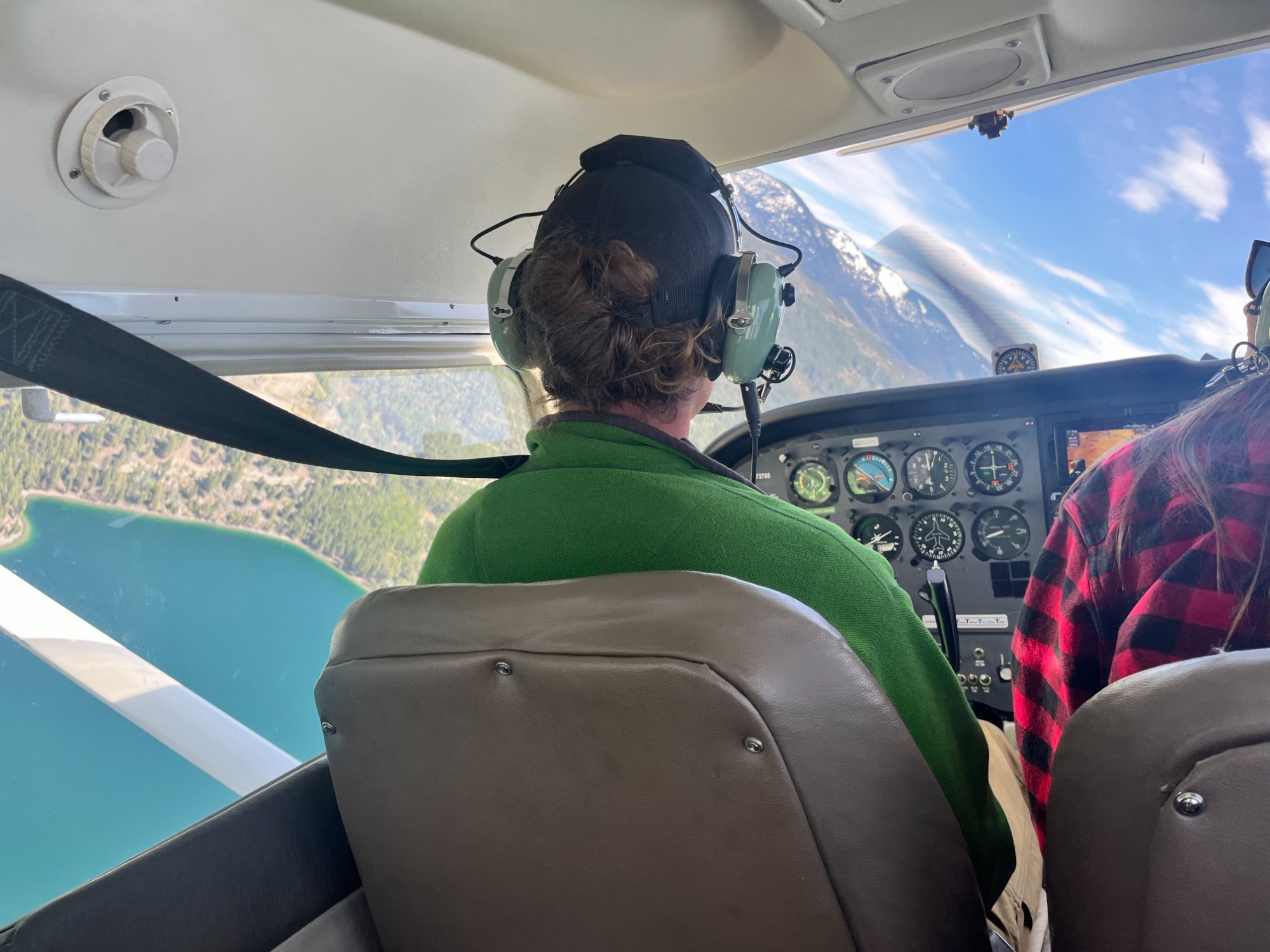 Cockpit view flying over lake and mountains